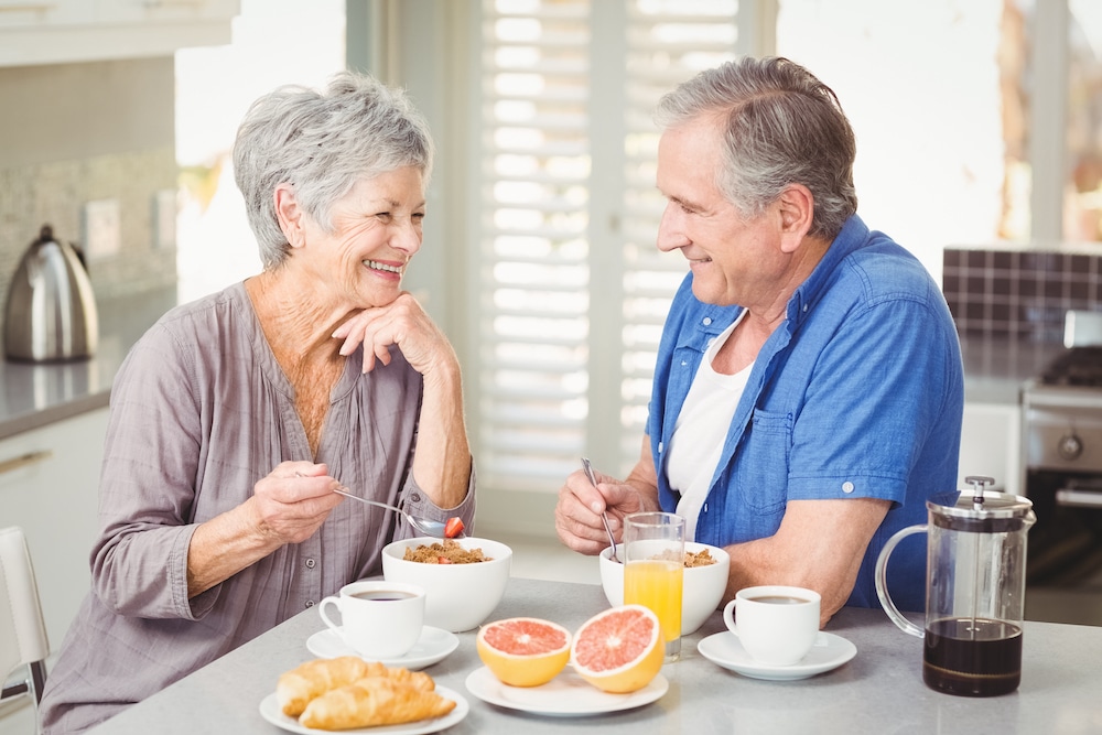A happy senior couple eating breakfast the senior living in Concord, CA