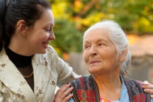 A young woman and her grandmother going on a fall walk outside at the Alzheimer's care in Concord, CA
