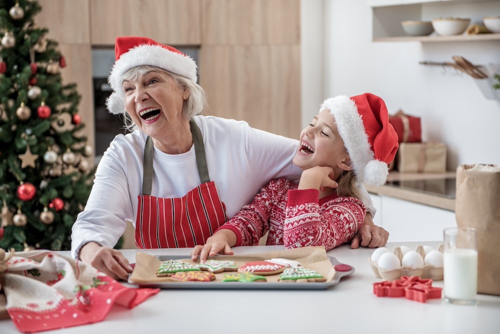 A resident of the Alzheimer's and dementia care in Concord, CA and her granddaughter bake cookies